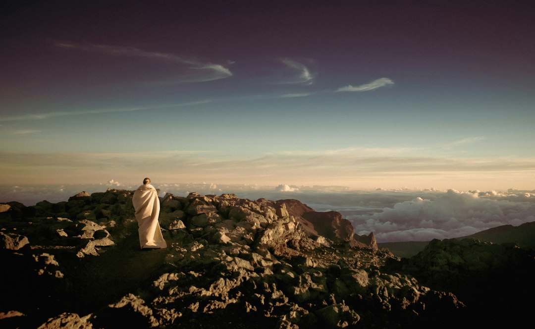 Solitary figure on a rocky mountain evoking Moses and sacred law